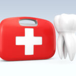 Tooth next to a red and white first aid kit to treat a dental emergency in Dallas, TX