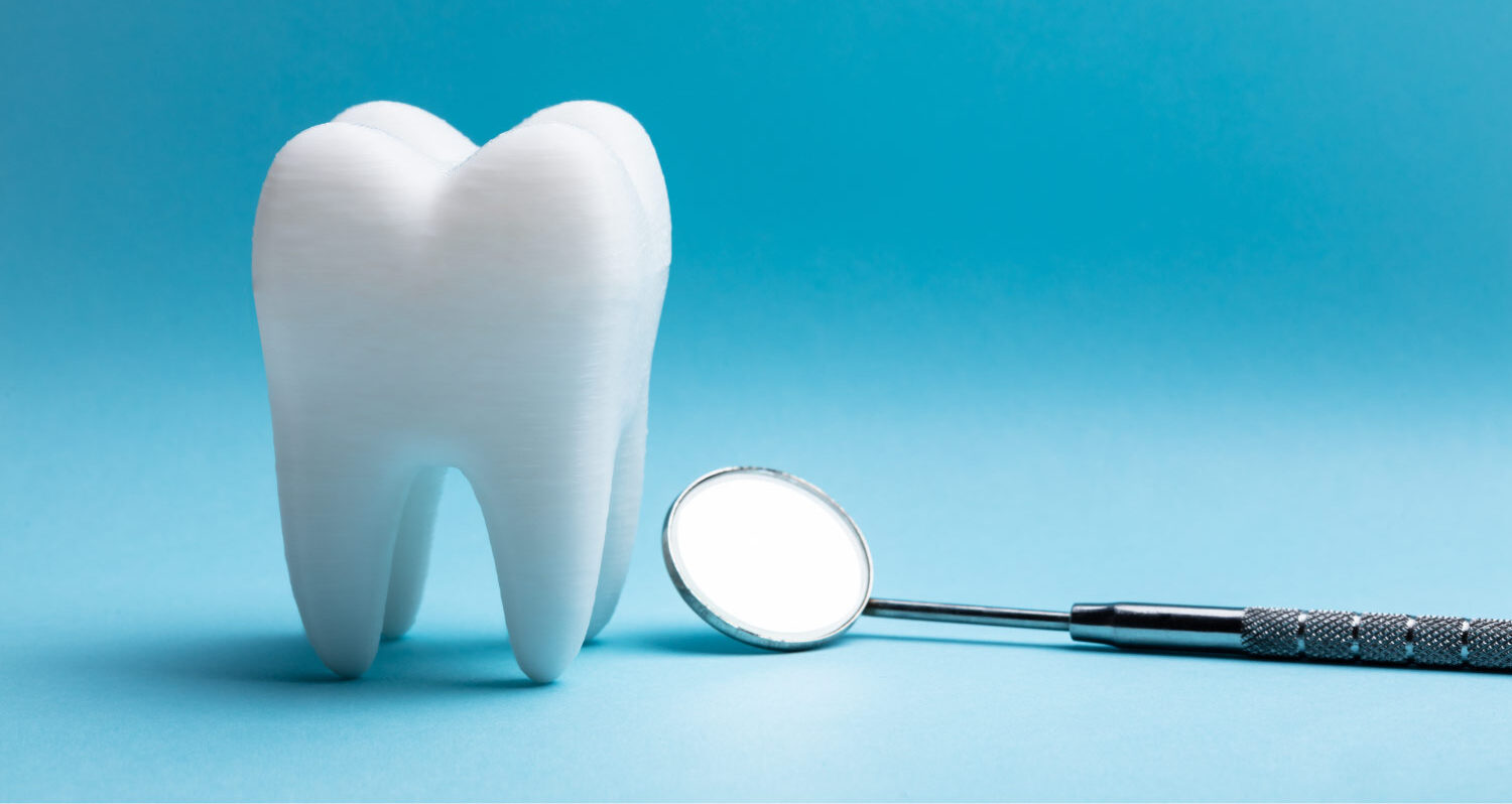A white tooth next to a special dental mirror against a blue background in Dallas, TX